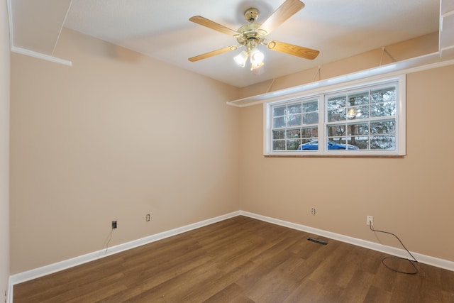 unfurnished room featuring baseboards, visible vents, and wood finished floors