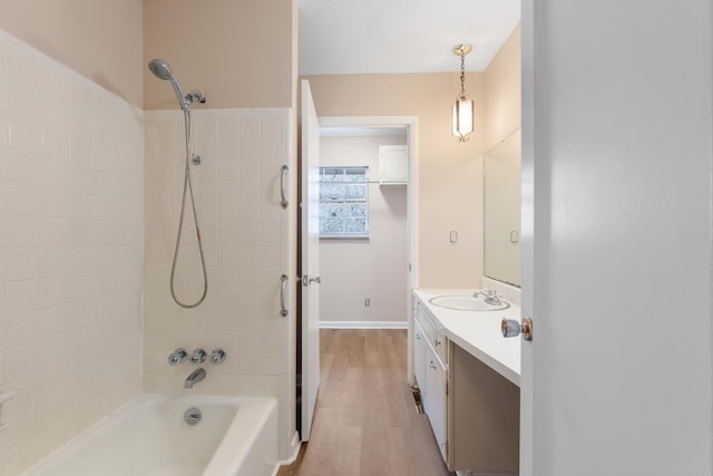 full bath featuring baseboards, vanity, shower / bath combination, and wood finished floors