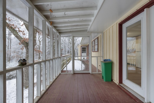 unfurnished sunroom featuring beam ceiling