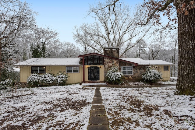 view of front of property with stone siding and a chimney