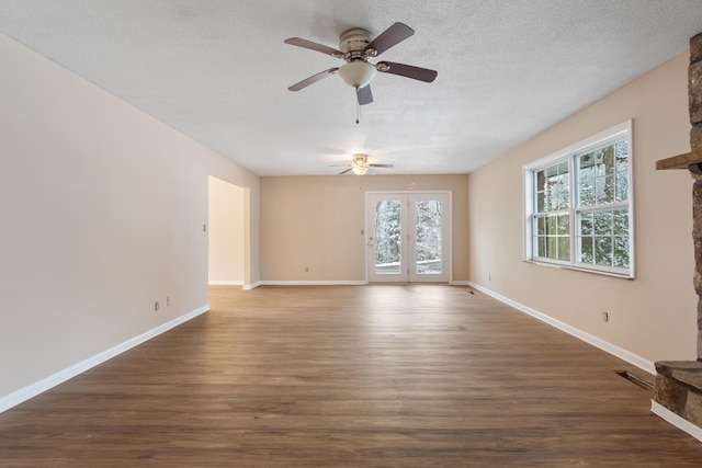 unfurnished room with dark wood-style floors, visible vents, a ceiling fan, baseboards, and a textured ceiling