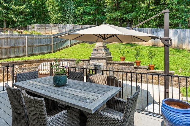 deck featuring an outdoor stone fireplace and a patio area