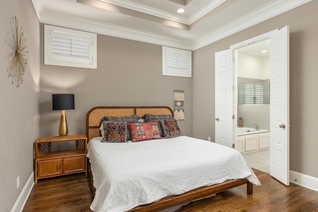 bedroom featuring crown molding, a tray ceiling, connected bathroom, and dark hardwood / wood-style flooring