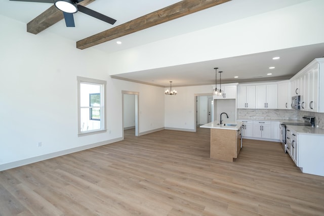 kitchen with backsplash, white cabinets, stainless steel appliances, a center island with sink, and beam ceiling