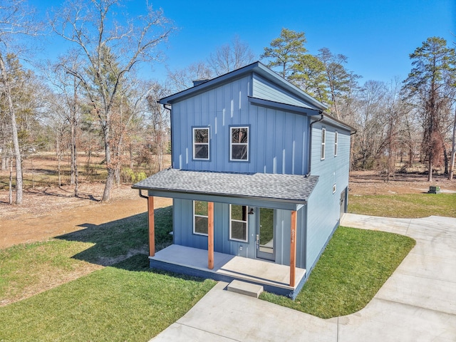 view of front of house featuring roof with shingles, board and batten siding, and a front yard