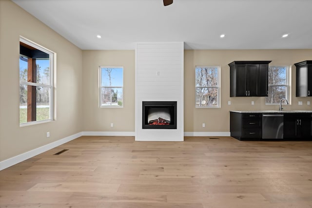 unfurnished living room with a wealth of natural light, recessed lighting, visible vents, and light wood finished floors