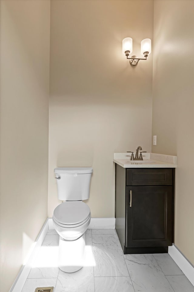 bathroom featuring marble finish floor, vanity, and baseboards