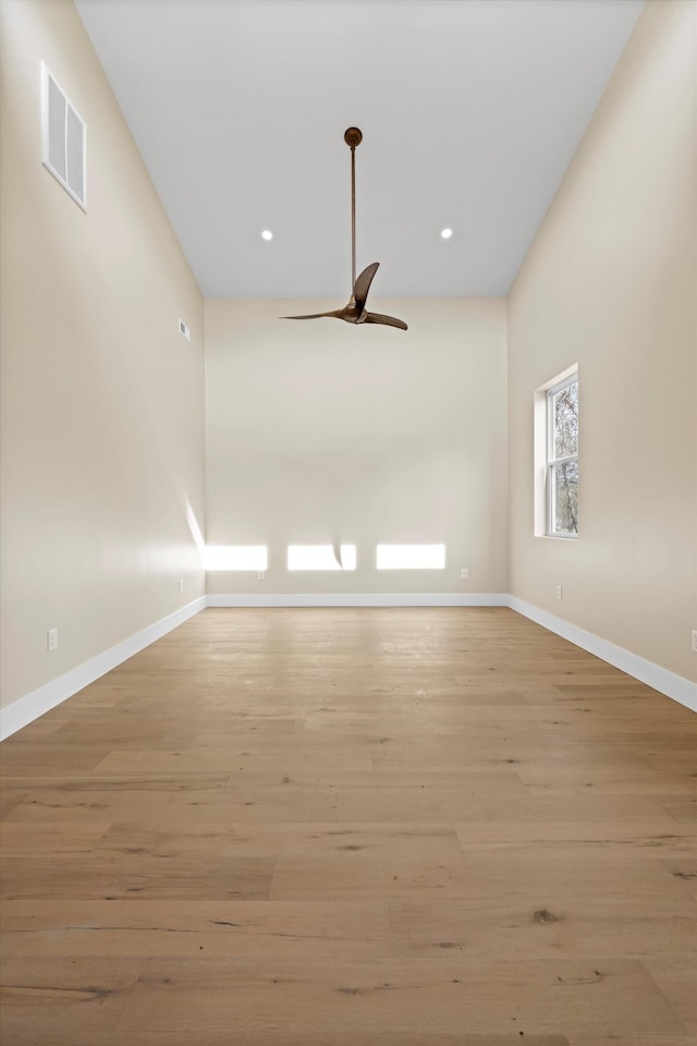 unfurnished room featuring light wood-type flooring, visible vents, ceiling fan, and baseboards