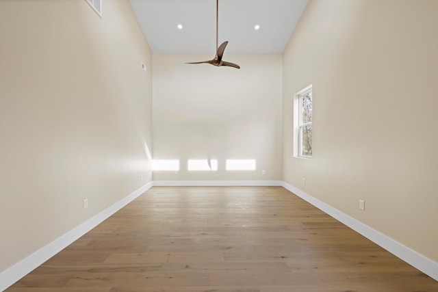 empty room with ceiling fan, baseboards, wood finished floors, and recessed lighting