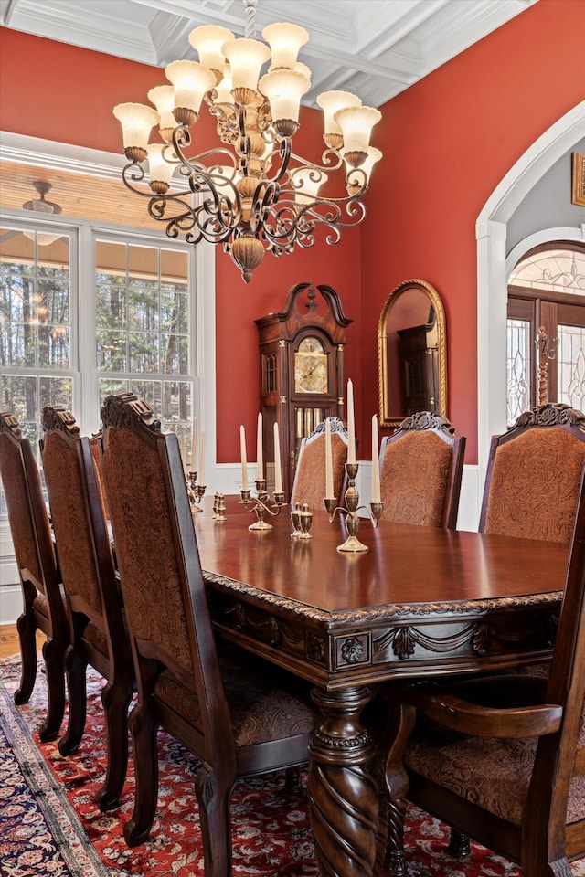 dining area with an inviting chandelier, ornamental molding, coffered ceiling, and a wealth of natural light