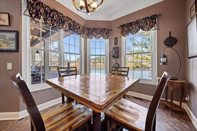 dining area with a notable chandelier, crown molding, and baseboards