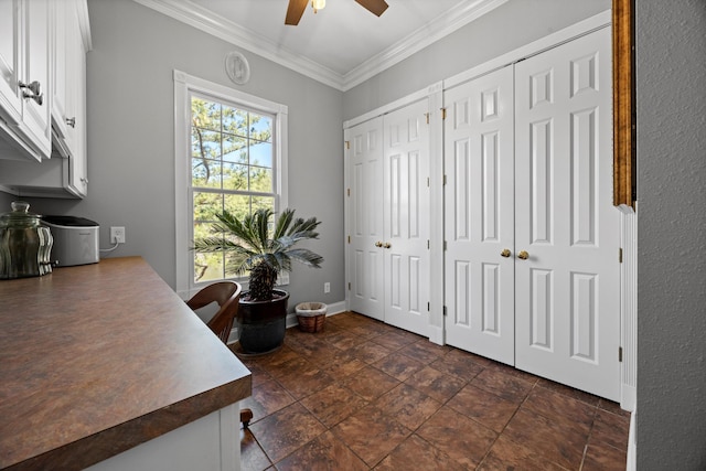 home office featuring stone finish flooring, crown molding, baseboards, and ceiling fan