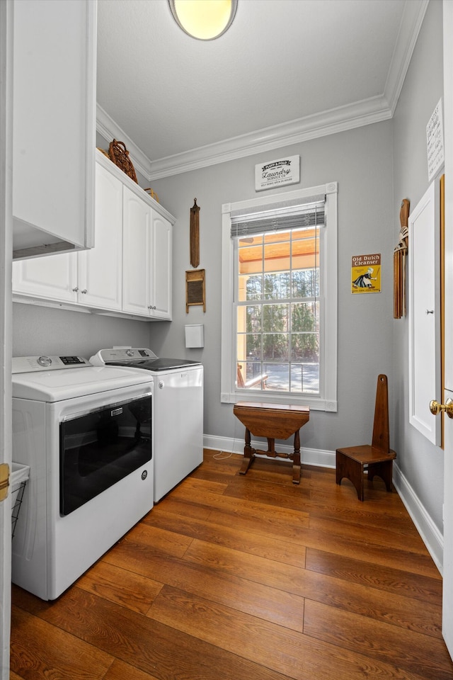 washroom with cabinet space, crown molding, dark wood-type flooring, and washer and dryer