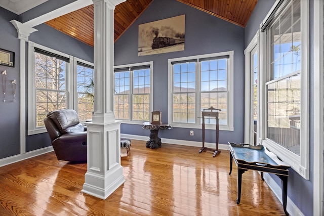 living area featuring light wood-type flooring, wood ceiling, and decorative columns