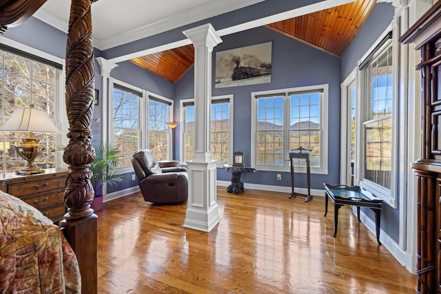 living area with wooden ceiling, ornate columns, baseboards, and wood finished floors