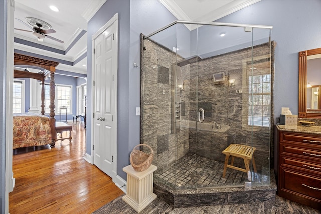 full bath with ceiling fan, ornamental molding, wood finished floors, vanity, and a shower stall