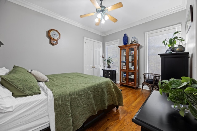 bedroom featuring ornamental molding, a ceiling fan, a closet, and wood finished floors