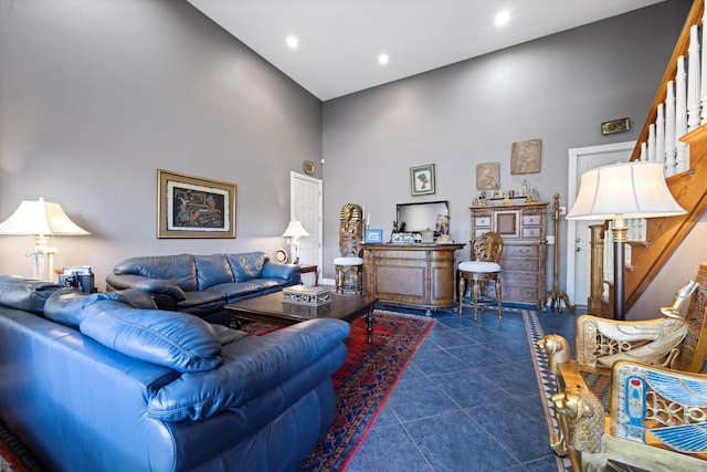 living room with stairs, dark tile patterned floors, a towering ceiling, and recessed lighting