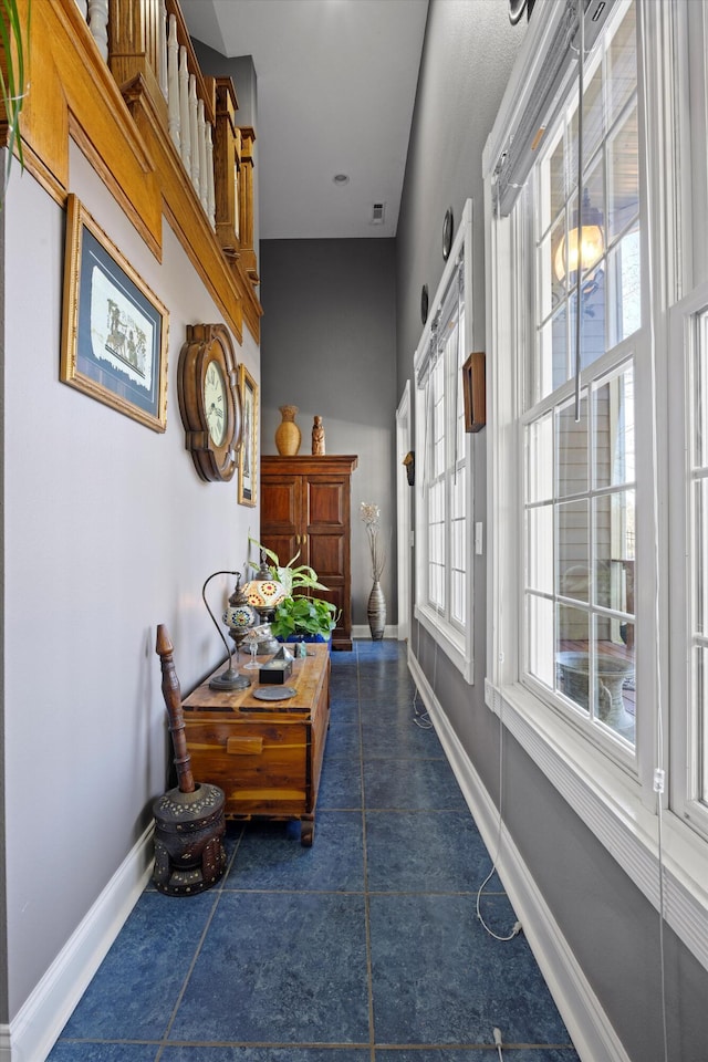 hall featuring visible vents and baseboards