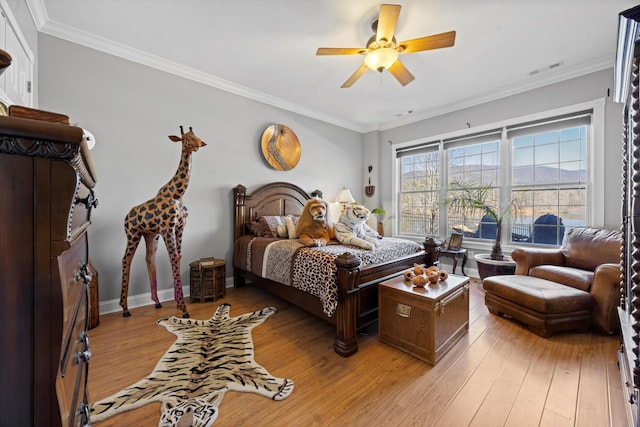 bedroom featuring ceiling fan, ornamental molding, visible vents, and light wood-style floors