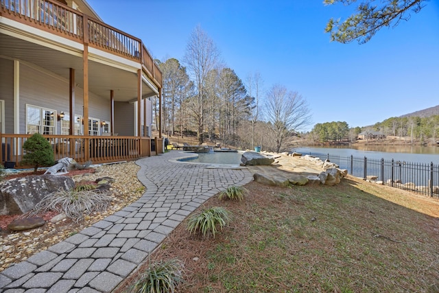 view of yard featuring a water view, fence, and a fenced in pool