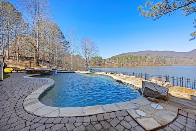 view of pool featuring a pool with connected hot tub, a water and mountain view, fence, and a patio