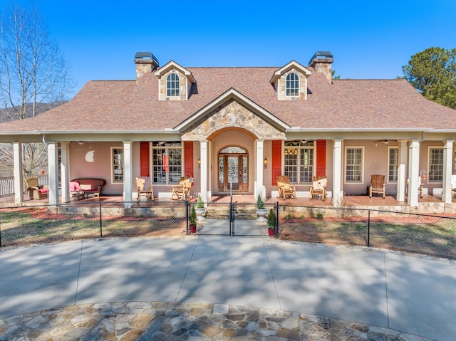 view of front of property featuring ceiling fan, a fenced front yard, a gate, stucco siding, and a chimney