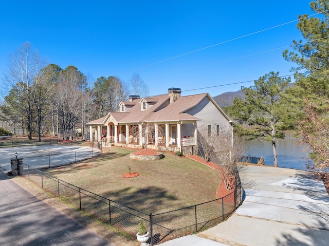 view of front of home featuring a shingled roof, concrete driveway, fence private yard, a front lawn, and a porch