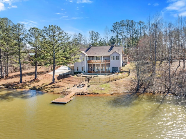 rear view of property with a water view, fence, and a balcony