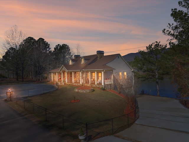 view of front facade with a front yard, driveway, and fence