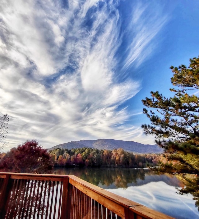 deck featuring a wooded view and a water and mountain view