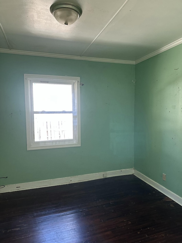 spare room featuring dark hardwood / wood-style flooring and ornamental molding