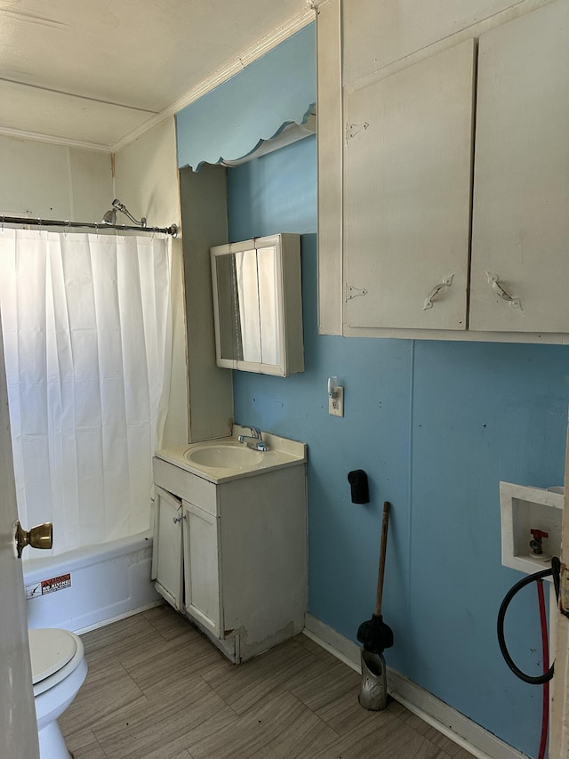 full bathroom featuring hardwood / wood-style floors, shower / bath combo with shower curtain, vanity, and toilet