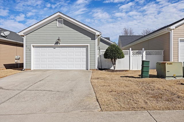 exterior space with concrete driveway, fence, and an attached garage