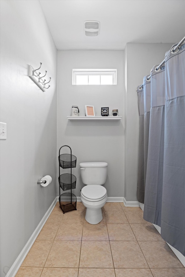 bathroom featuring tile patterned flooring, toilet, visible vents, baseboards, and a shower with curtain