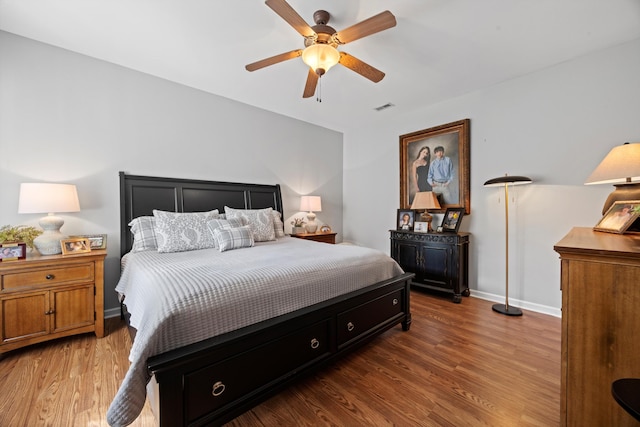 bedroom with baseboards, visible vents, ceiling fan, and wood finished floors