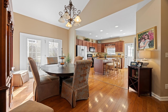 dining room featuring light wood-type flooring, an inviting chandelier, baseboards, and recessed lighting