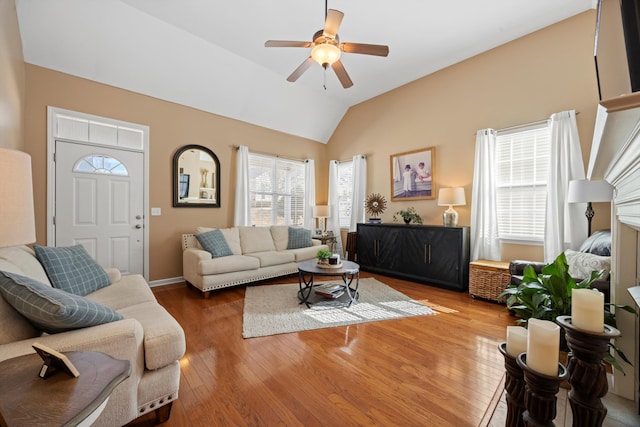 living room with lofted ceiling, baseboards, a ceiling fan, and wood finished floors