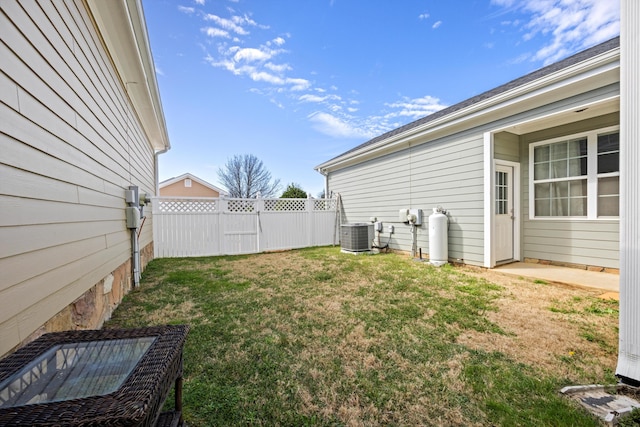 view of yard featuring central AC and fence