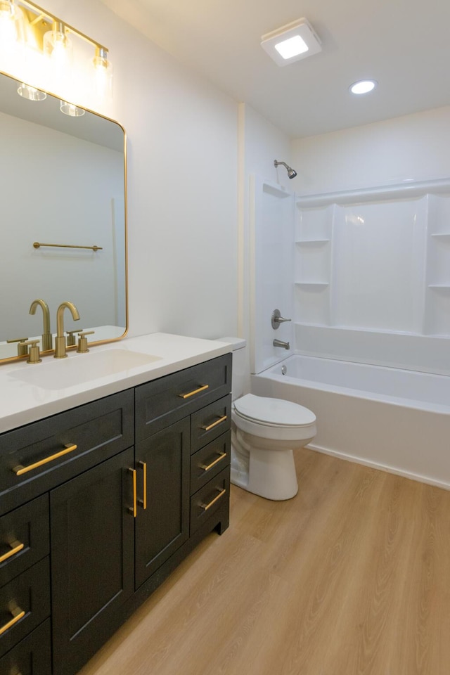 full bathroom featuring vanity, hardwood / wood-style floors, tub / shower combination, and toilet