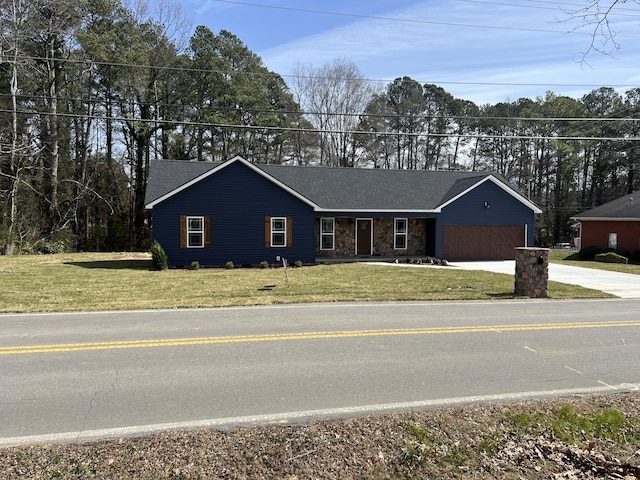 view of front of home with an attached garage, stone siding, a front lawn, and concrete driveway