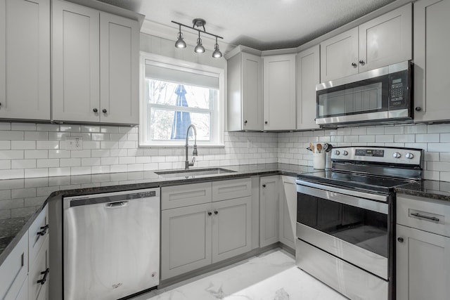 kitchen with tasteful backsplash, marble finish floor, stainless steel appliances, and a sink