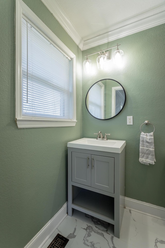 bathroom featuring vanity, crown molding, baseboards, and marble finish floor