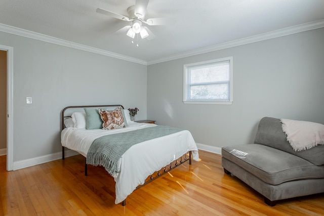 bedroom featuring crown molding, light wood-type flooring, and baseboards