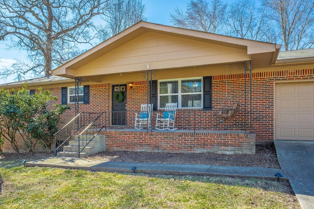 view of front of house with a porch, a garage, and brick siding