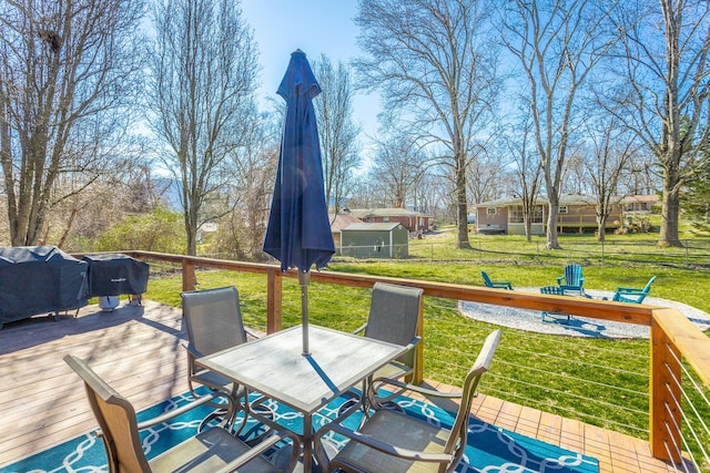 wooden terrace with area for grilling and a yard