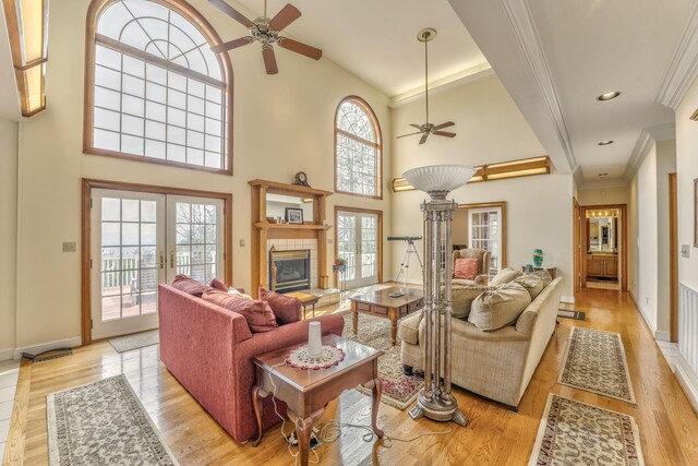 815 Battlefield Park Dr, Dalton, GA 30720 - living room featuring light hardwood / wood-style flooring, a high ceiling, ornamental molding, a tiled fireplace, and french doors