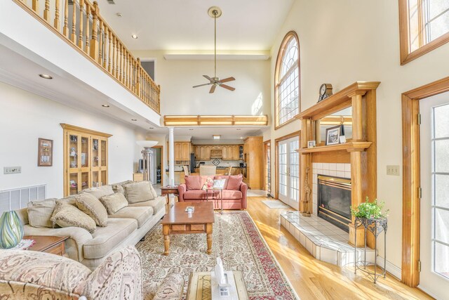 815 Battlefield Park Dr, Dalton, GA 30720 - living room with a towering ceiling, light hardwood / wood-style flooring, a tile fireplace, and ceiling fan