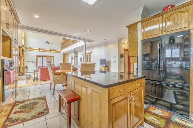 815 Battlefield Park Dr, Dalton, GA 30720 - kitchen with light tile patterned floors, crown molding, ceiling fan, black refrigerator, and a kitchen island