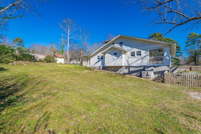 rear view of house featuring a yard, ceiling fan, and fence